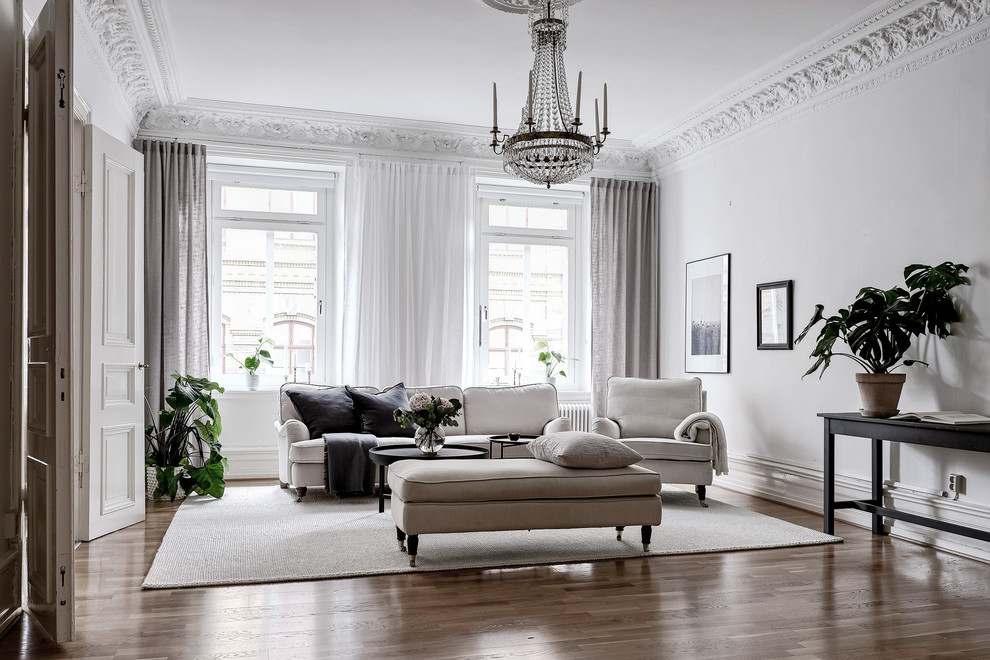 На фото: большая парадная, изолированная гостиная комната в скандинавском стиле с белыми стенами, паркетным полом среднего тона и коричневым полом без камина, телевизора
