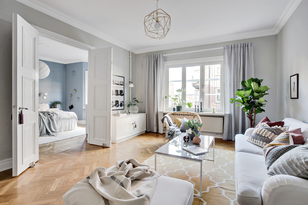 Scandinavian formal enclosed living room in Gothenburg with grey walls, light hardwood flooring, no tv and beige floors.
