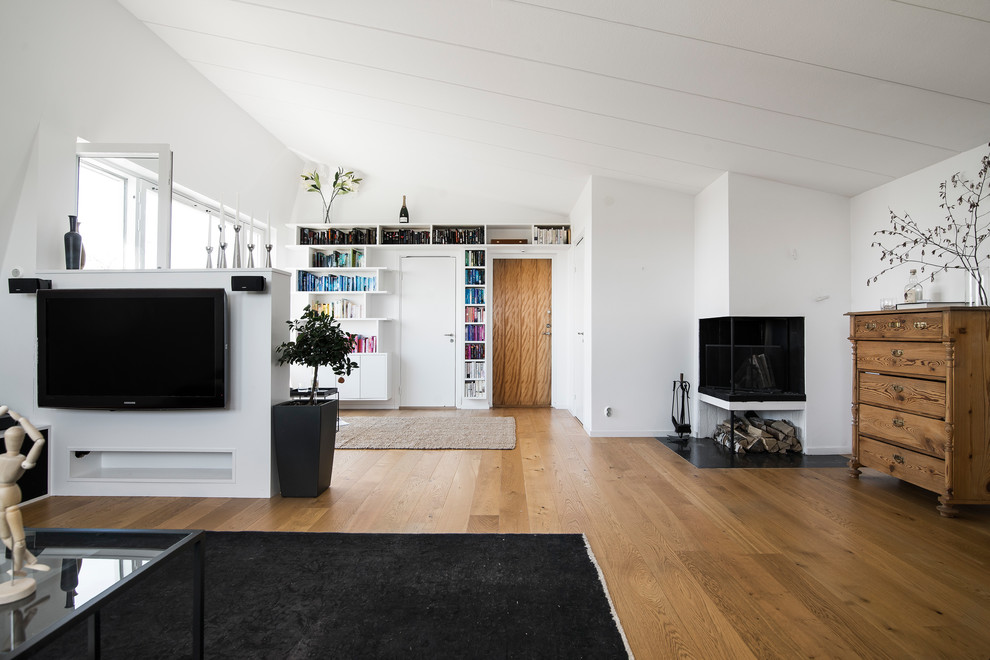 Bild på ett skandinaviskt allrum med öppen planlösning, med vita väggar, mellanmörkt trägolv, en dubbelsidig öppen spis, en väggmonterad TV och brunt golv