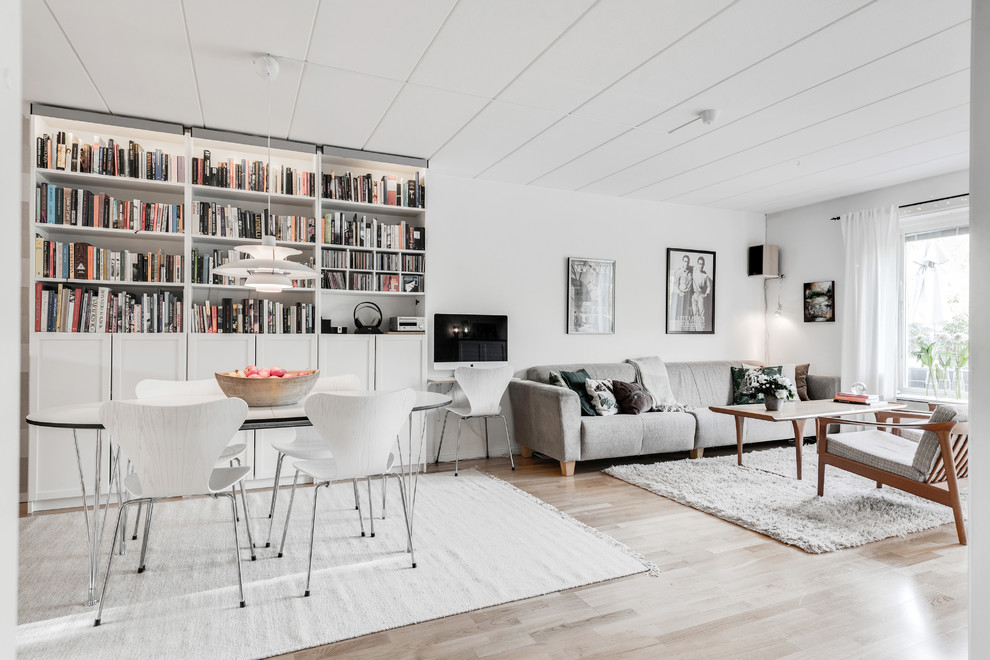 На фото: открытая гостиная комната среднего размера в скандинавском стиле с домашним баром, белыми стенами и светлым паркетным полом без телевизора с