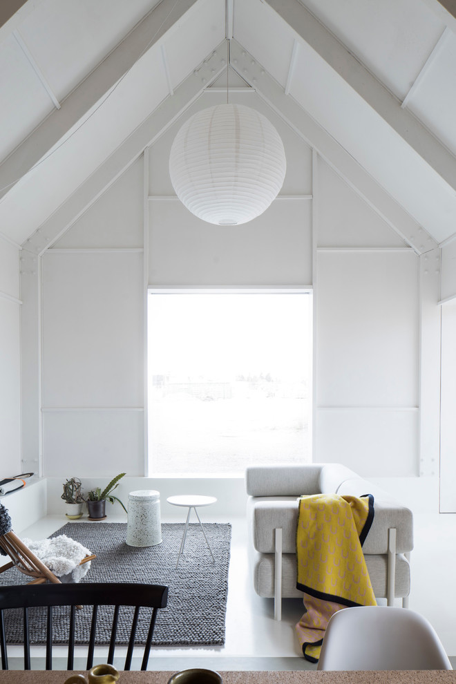 На фото: парадная, открытая гостиная комната среднего размера в скандинавском стиле с белыми стенами и бетонным полом без телевизора