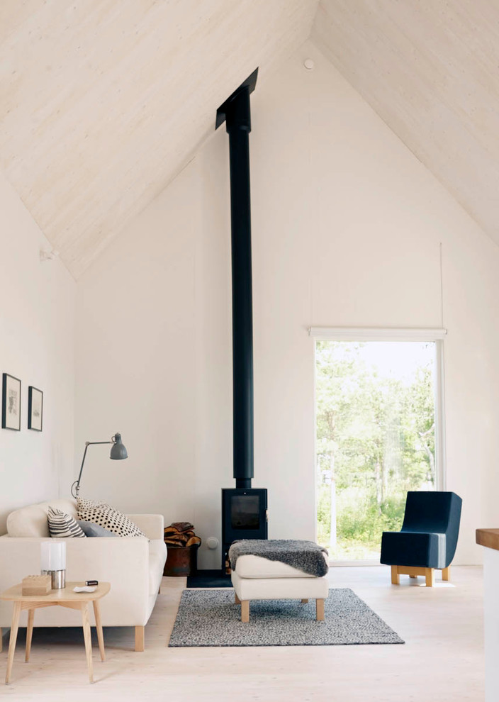 Immagine di un ampio soggiorno nordico aperto con sala formale, pareti bianche, parquet chiaro e stufa a legna