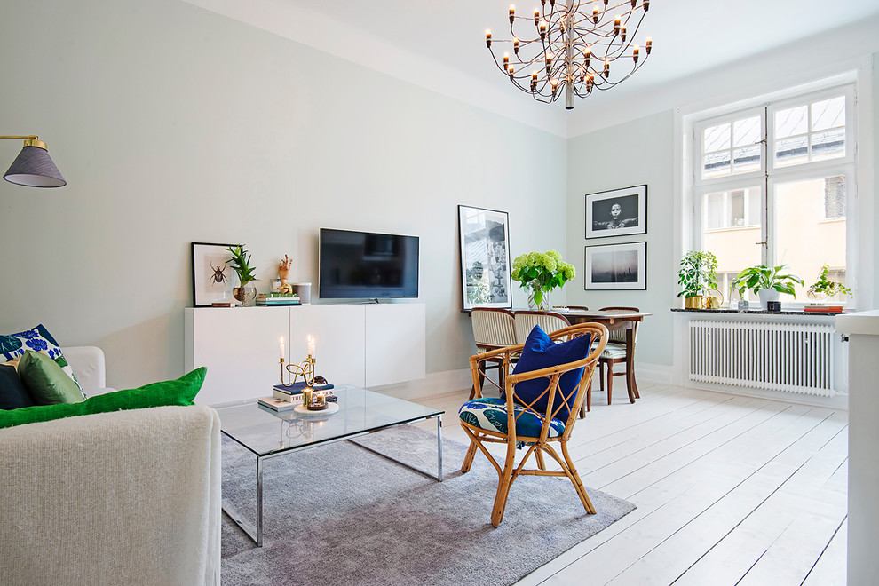 Exemple d'un salon chic ouvert et de taille moyenne avec un mur gris, parquet peint, un téléviseur indépendant, une salle de réception et aucune cheminée.