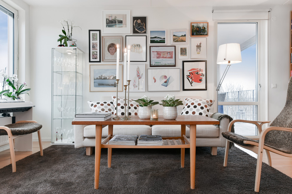 Bild på ett litet minimalistiskt vardagsrum, med vita väggar, ljust trägolv och brunt golv