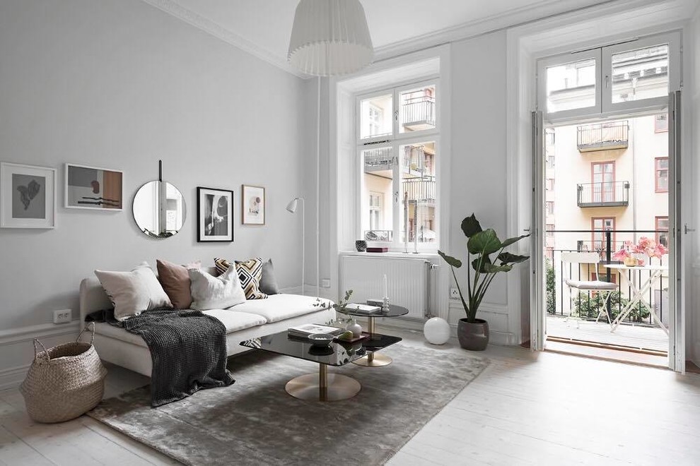 Photo of a medium sized scandi enclosed living room in Stockholm with grey walls, light hardwood flooring, no fireplace and grey floors.