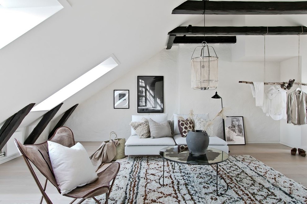 Skandinavisk inredning av ett mellanstort loftrum, med vita väggar, ljust trägolv, beiget golv och ett finrum