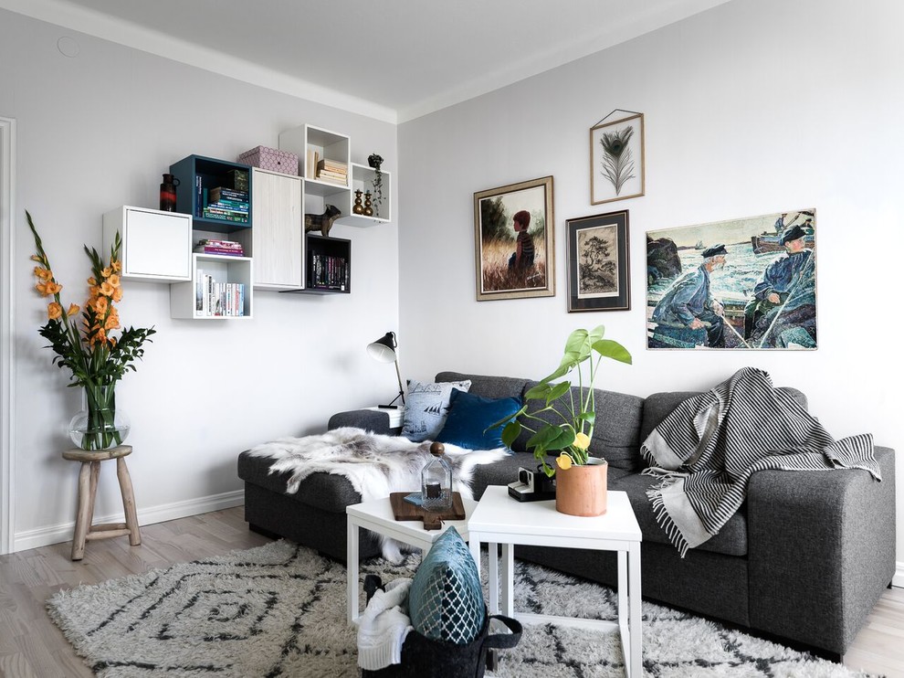 Immagine di un piccolo soggiorno scandinavo con pareti bianche, parquet chiaro e pavimento beige