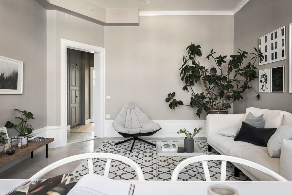 Abgetrenntes Skandinavisches Wohnzimmer ohne Kamin mit grauer Wandfarbe und Betonboden in Stockholm