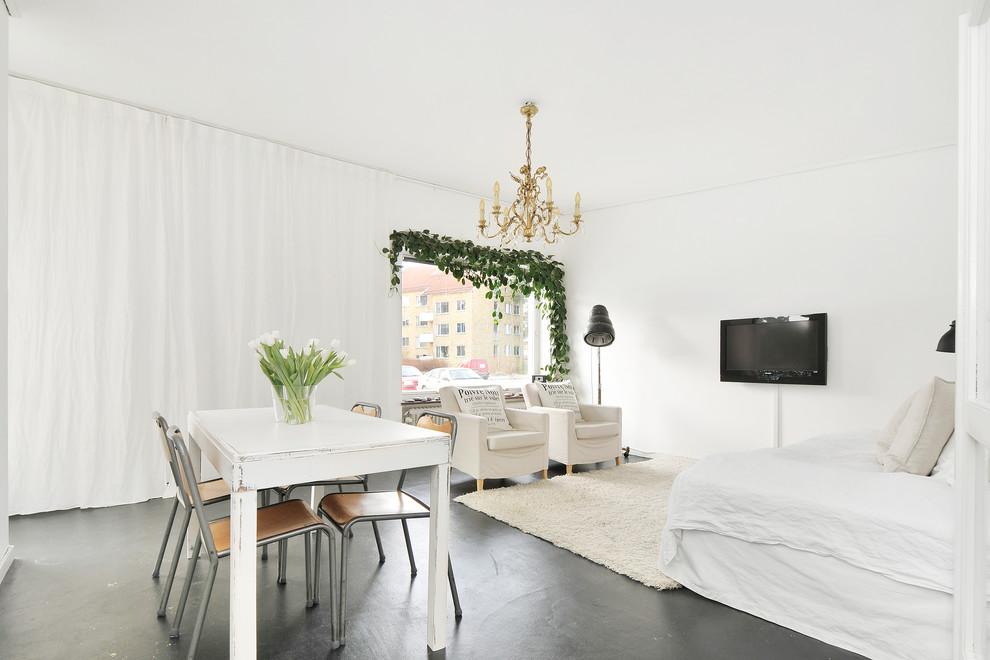 Foto de salón abierto romántico de tamaño medio con paredes blancas, suelo de cemento y televisor colgado en la pared