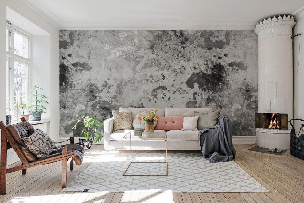 Foto på ett skandinaviskt vardagsrum, med grå väggar, ljust trägolv, en öppen vedspis och beiget golv
