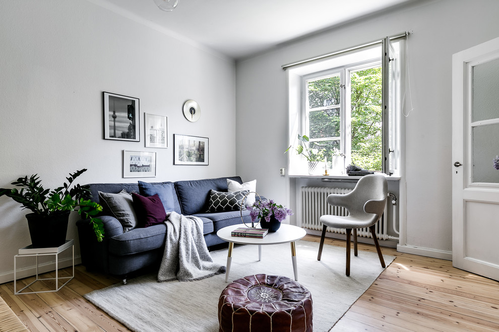 Example of a small danish light wood floor and beige floor living room design in Stockholm with gray walls