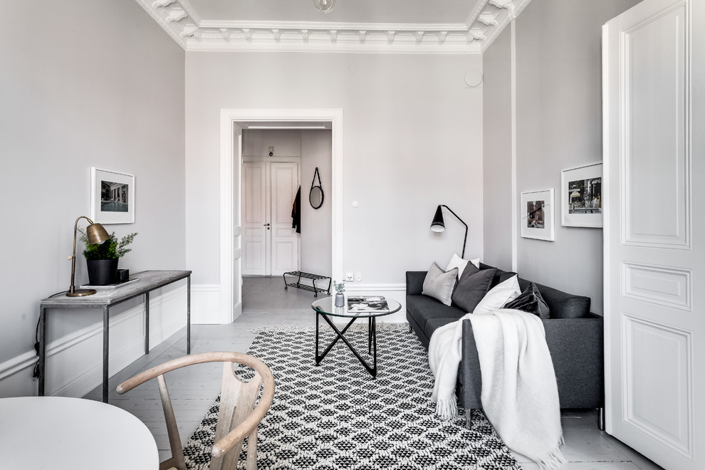 Идея дизайна: изолированная, парадная гостиная комната среднего размера в скандинавском стиле с серыми стенами и деревянным полом без телевизора
