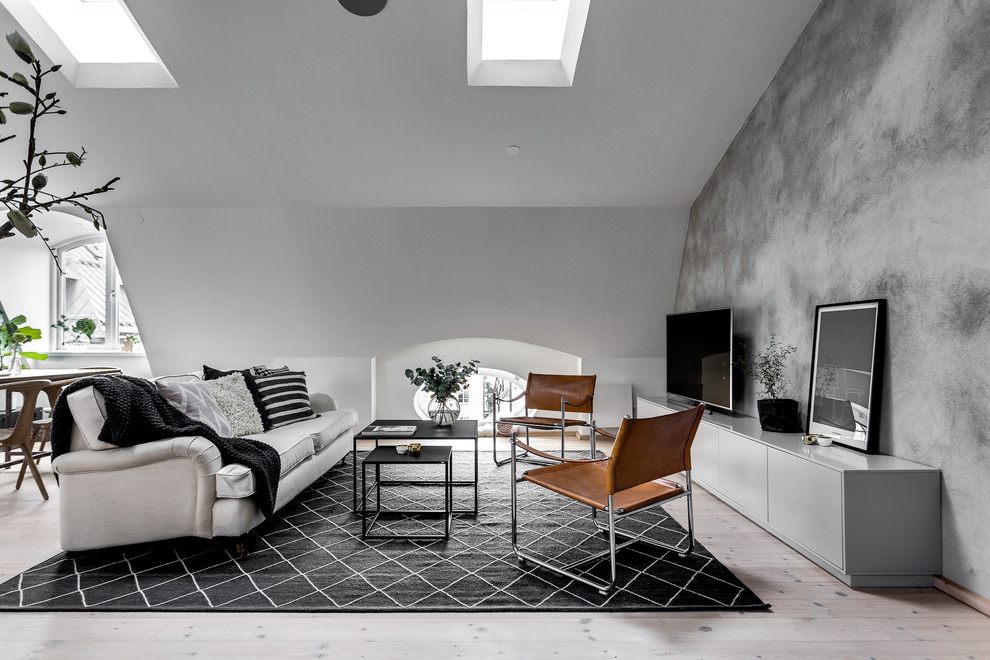 Offenes, Großes Skandinavisches Wohnzimmer ohne Kamin mit grauer Wandfarbe, hellem Holzboden und freistehendem TV in Stockholm