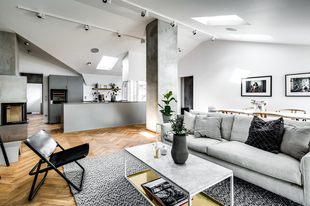 Esempio di un soggiorno scandinavo di medie dimensioni e aperto con pareti bianche, pavimento in legno massello medio e pavimento marrone