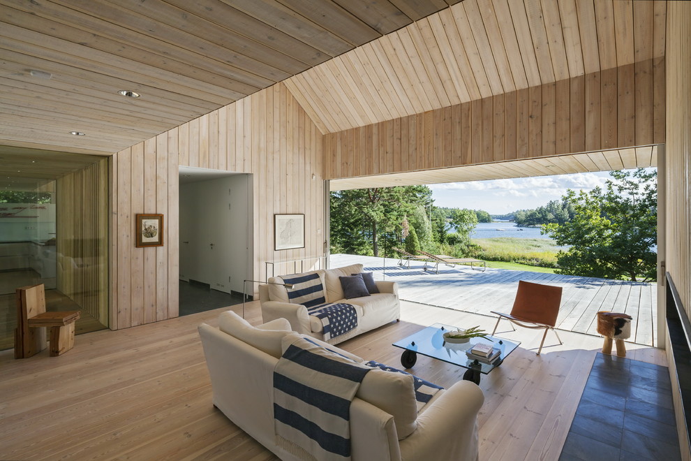 Bild på ett minimalistiskt allrum med öppen planlösning, med beige väggar, ljust trägolv, beiget golv och en bred öppen spis