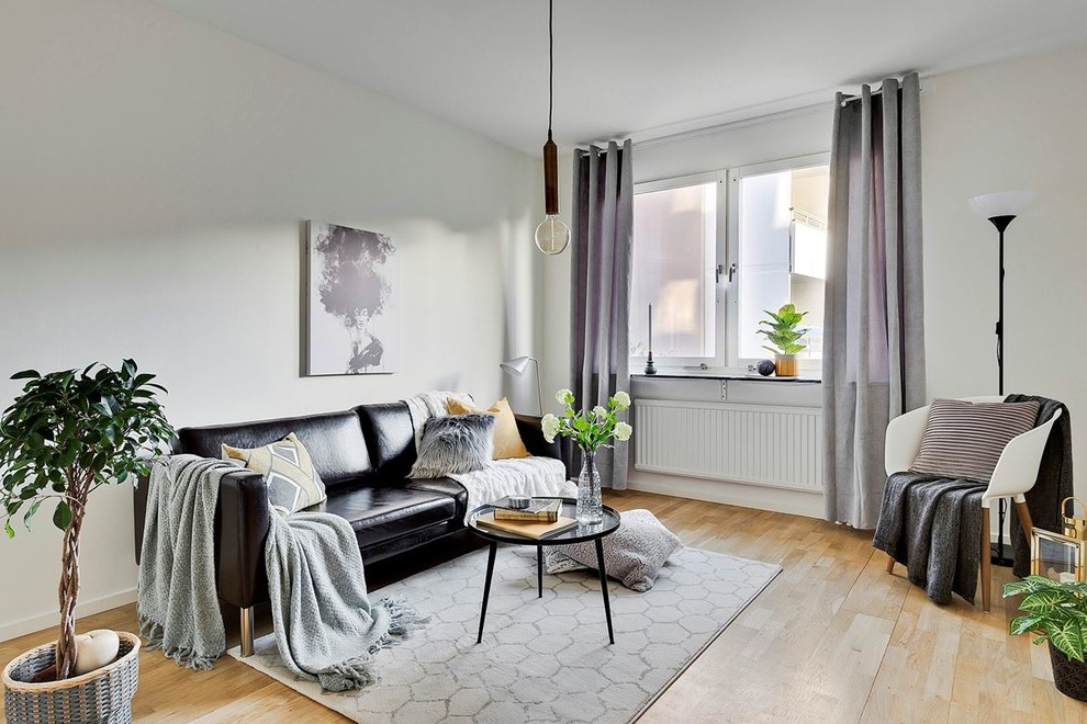 Идея дизайна: гостиная комната в скандинавском стиле с белыми стенами и светлым паркетным полом