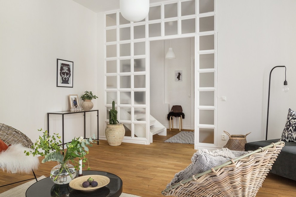 Идея дизайна: гостиная комната в скандинавском стиле с белыми стенами, паркетным полом среднего тона и коричневым полом без камина