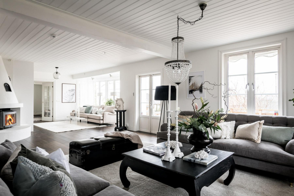 Idee per un soggiorno nordico aperto con pareti bianche, parquet scuro, pavimento marrone e soffitto in perlinato