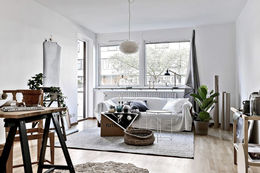 Diseño de salón abierto nórdico con paredes blancas y suelo de madera clara