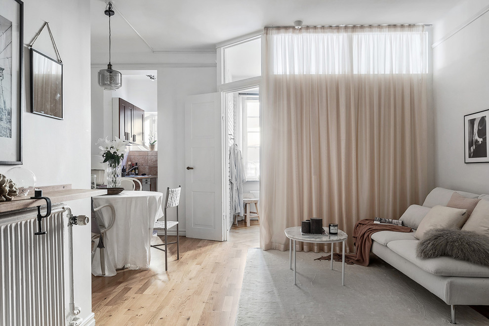 Idées déco pour un petit salon scandinave avec un mur blanc, un sol en bois brun, aucune cheminée et aucun téléviseur.