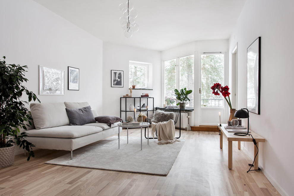 Inspiration for a medium sized scandinavian formal enclosed living room in Stockholm with white walls, light hardwood flooring, beige floors and no tv.