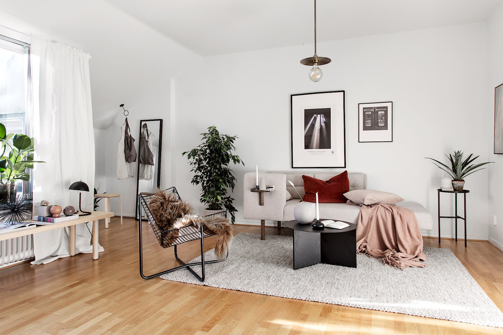Diseño de salón abierto nórdico pequeño con paredes blancas y suelo de madera clara