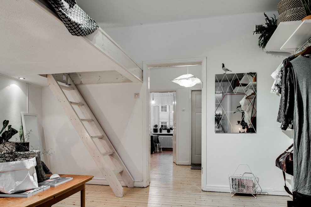 Kleines, Abgetrenntes Nordisches Wohnzimmer ohne Kamin mit weißer Wandfarbe, hellem Holzboden und freistehendem TV in Göteborg