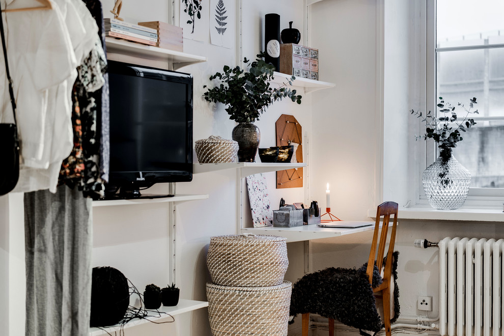 Foto på ett litet minimalistiskt separat vardagsrum, med vita väggar, ljust trägolv och en fristående TV