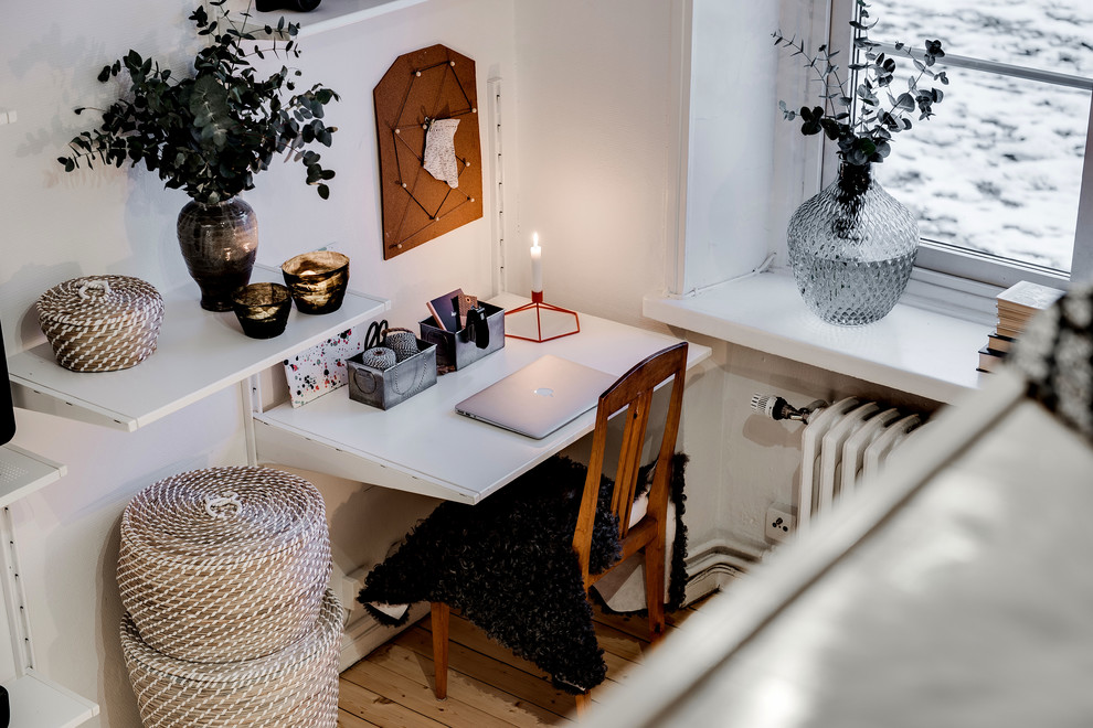 ヨーテボリにある小さな北欧スタイルのおしゃれな独立型リビング (白い壁、淡色無垢フローリング、暖炉なし、据え置き型テレビ) の写真