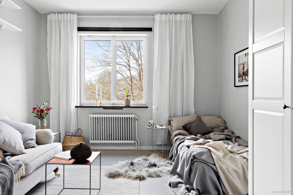 Scandi enclosed living room in Stockholm with grey walls, concrete flooring and grey floors.