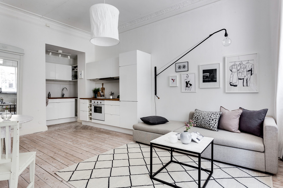 Inspiration för ett mellanstort skandinaviskt allrum med öppen planlösning, med vita väggar och ljust trägolv