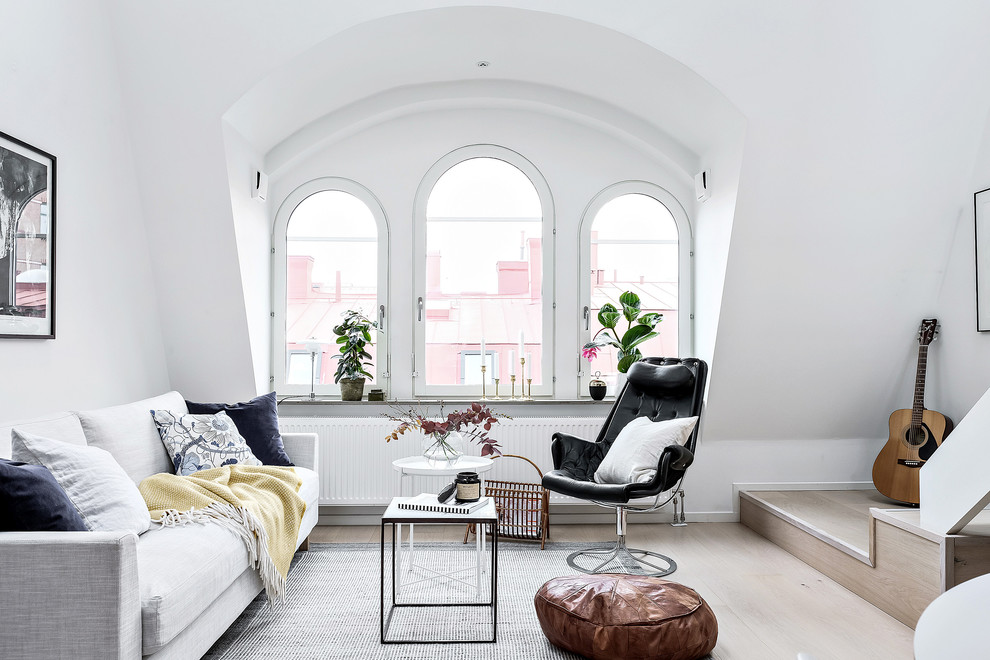 Diseño de salón abierto escandinavo de tamaño medio sin chimenea con paredes blancas, suelo de madera clara y suelo beige