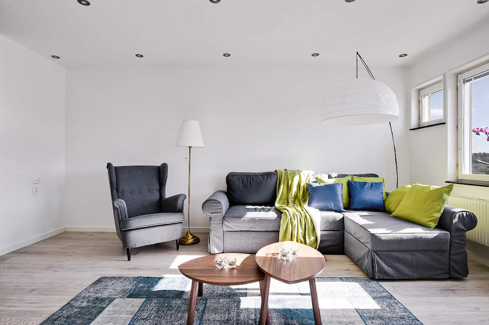 Modelo de salón abierto escandinavo de tamaño medio sin chimenea y televisor con paredes blancas y suelo de madera clara