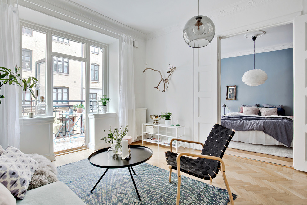 На фото: открытая, парадная гостиная комната среднего размера в скандинавском стиле с белыми стенами и светлым паркетным полом без телевизора