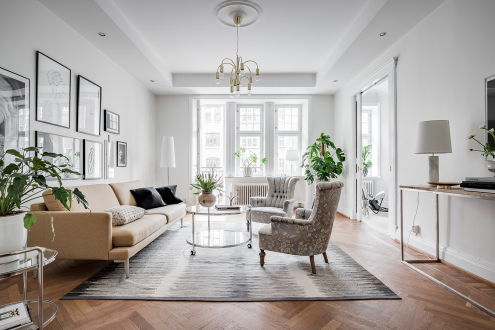 Large classic formal enclosed living room in Gothenburg with white walls and medium hardwood flooring.