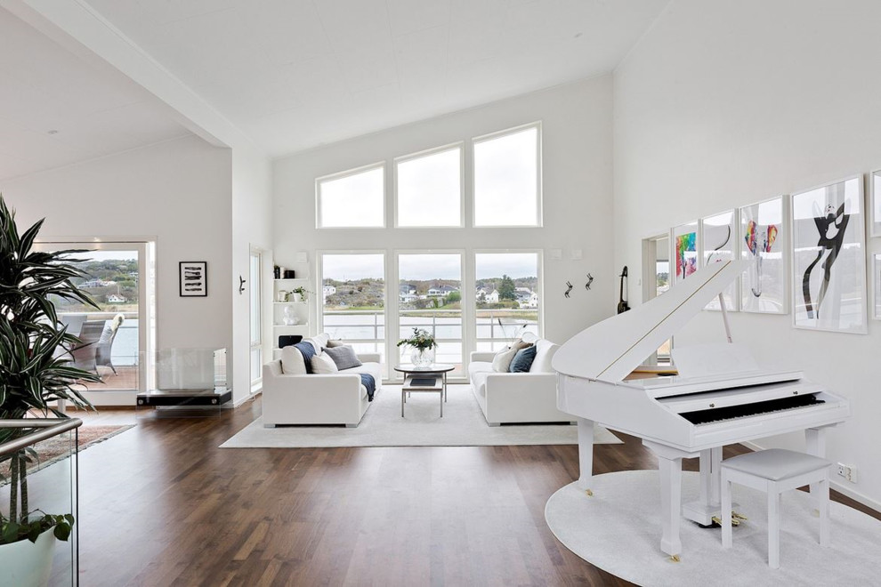 Inspiration pour un grand salon minimaliste avec un mur blanc et un sol marron.