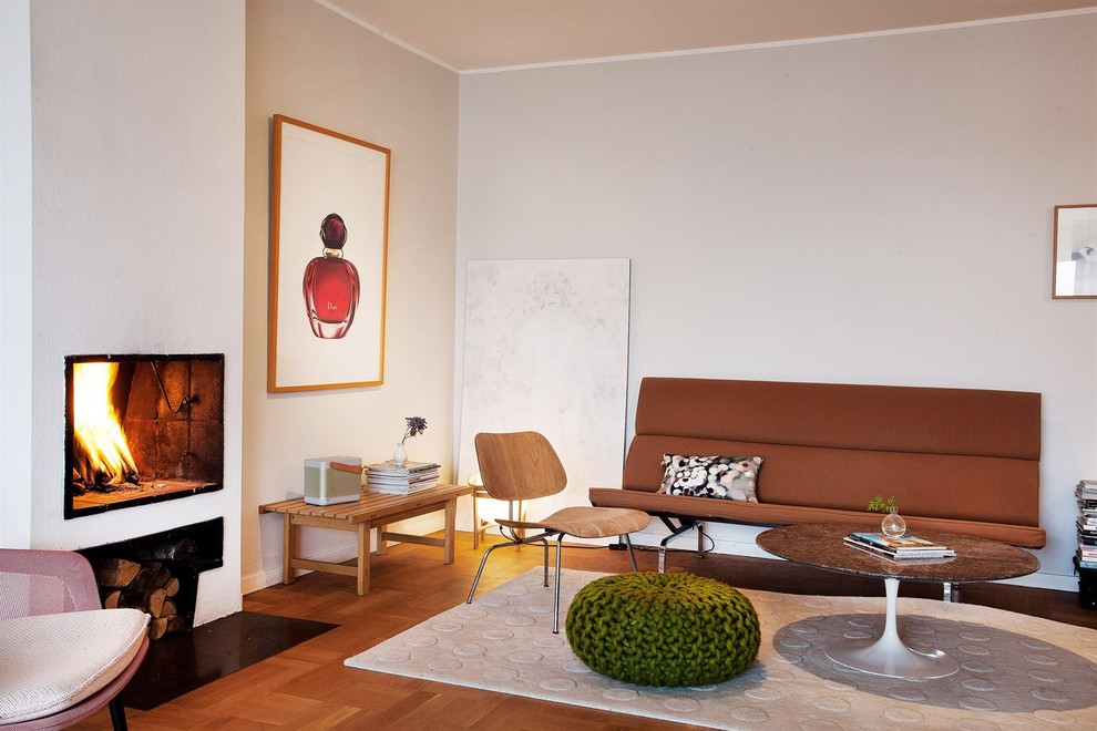 Example of a mid-sized mid-century modern formal and open concept medium tone wood floor living room design in Stockholm with white walls, no fireplace and no tv