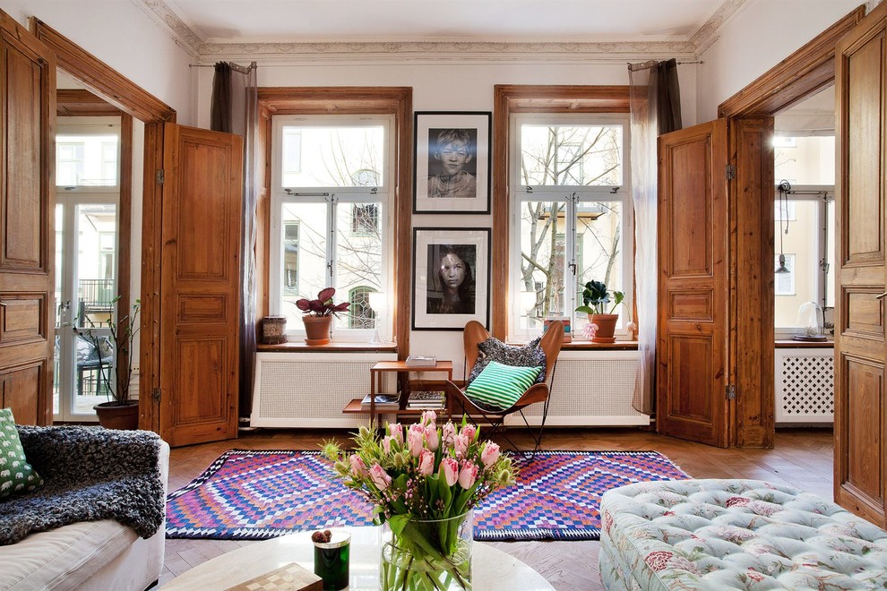 Example of a large ornate formal and open concept light wood floor living room design in Stockholm with white walls, no fireplace and no tv