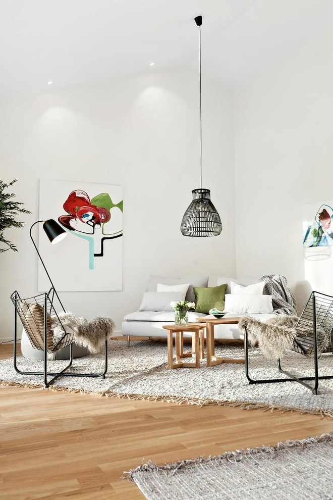 Living room - scandinavian open concept medium tone wood floor and brown floor living room idea in Stockholm with white walls