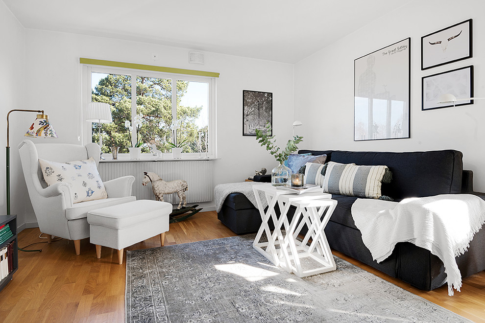 Bild på ett minimalistiskt vardagsrum, med vita väggar, mellanmörkt trägolv och brunt golv