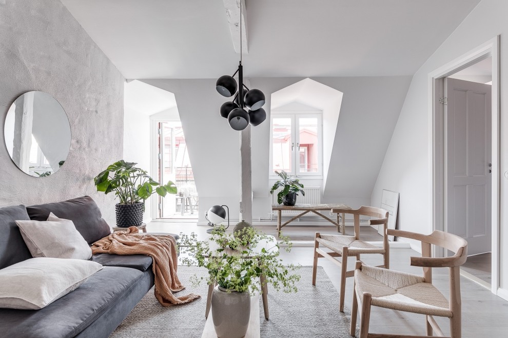 Scandi living room in Gothenburg with white walls, light hardwood flooring and beige floors.