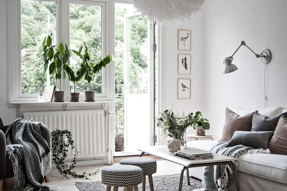 Photo of a medium sized scandinavian formal living room in Gothenburg with white walls, light hardwood flooring and no tv.