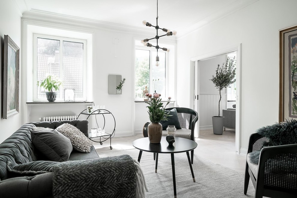 Immagine di un grande soggiorno scandinavo chiuso con sala formale, pareti bianche, parquet chiaro e pavimento bianco