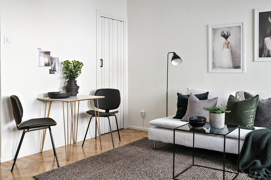 This is an example of a scandi living room in Stockholm with white walls and light hardwood flooring.