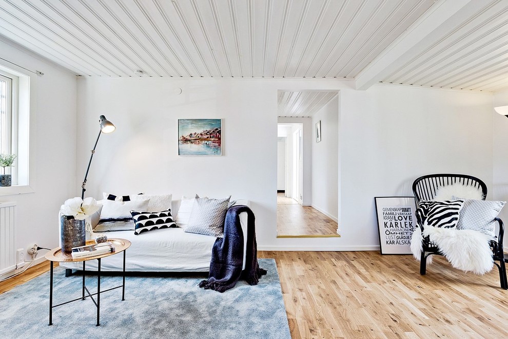 Esempio di un grande soggiorno scandinavo aperto con pareti bianche, parquet chiaro, sala formale, nessun camino e nessuna TV