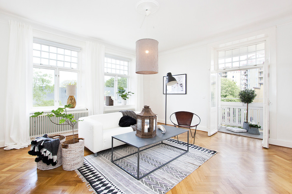 Immagine di un grande soggiorno scandinavo aperto con sala formale, pareti bianche, pavimento in legno massello medio, nessun camino e nessuna TV
