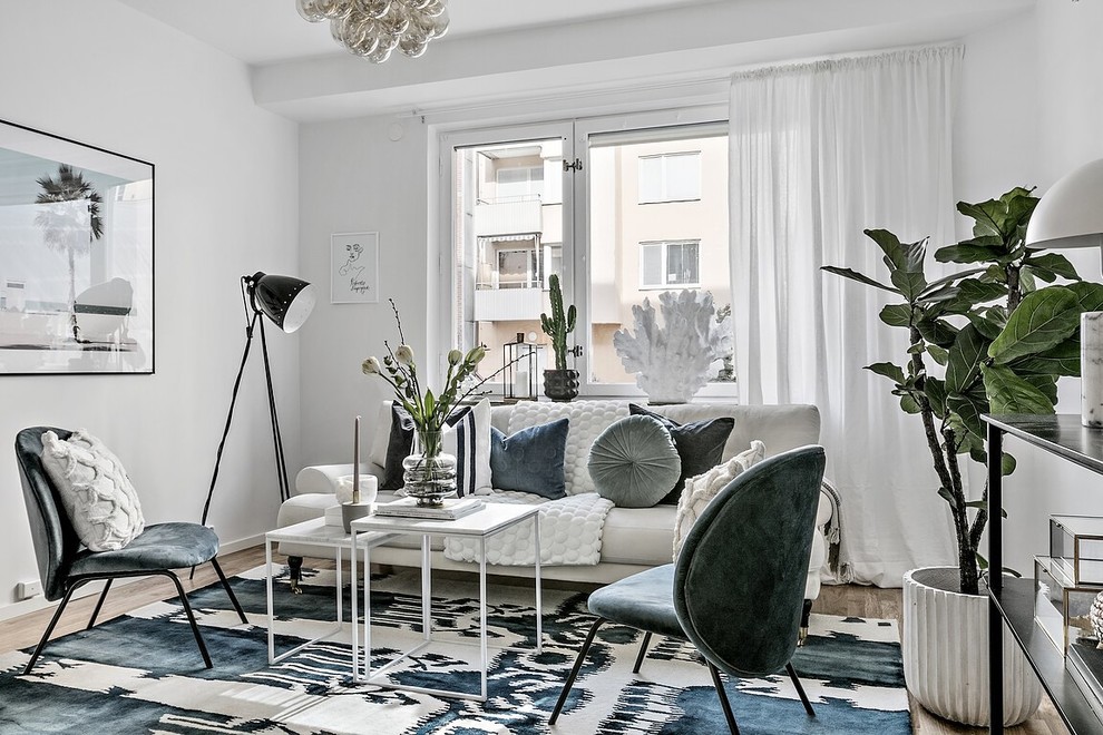 This is an example of a scandi living room in Stockholm with white walls, medium hardwood flooring and brown floors.