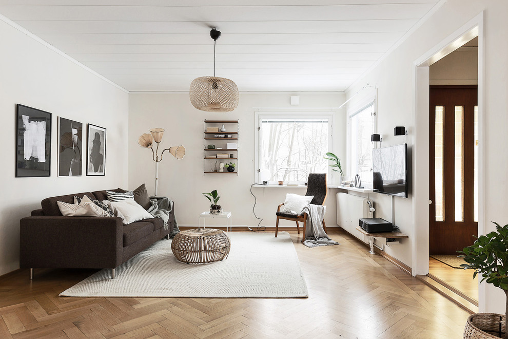 Foto på ett nordiskt separat vardagsrum, med vita väggar, mellanmörkt trägolv och en väggmonterad TV