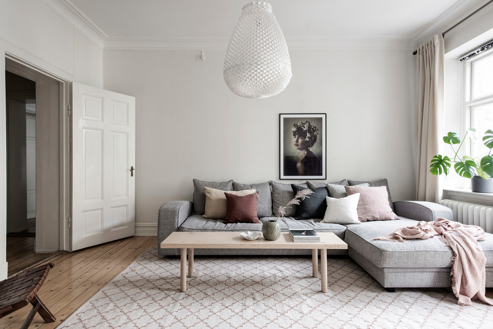Example of a danish formal and enclosed medium tone wood floor and beige floor living room design in Gothenburg with gray walls