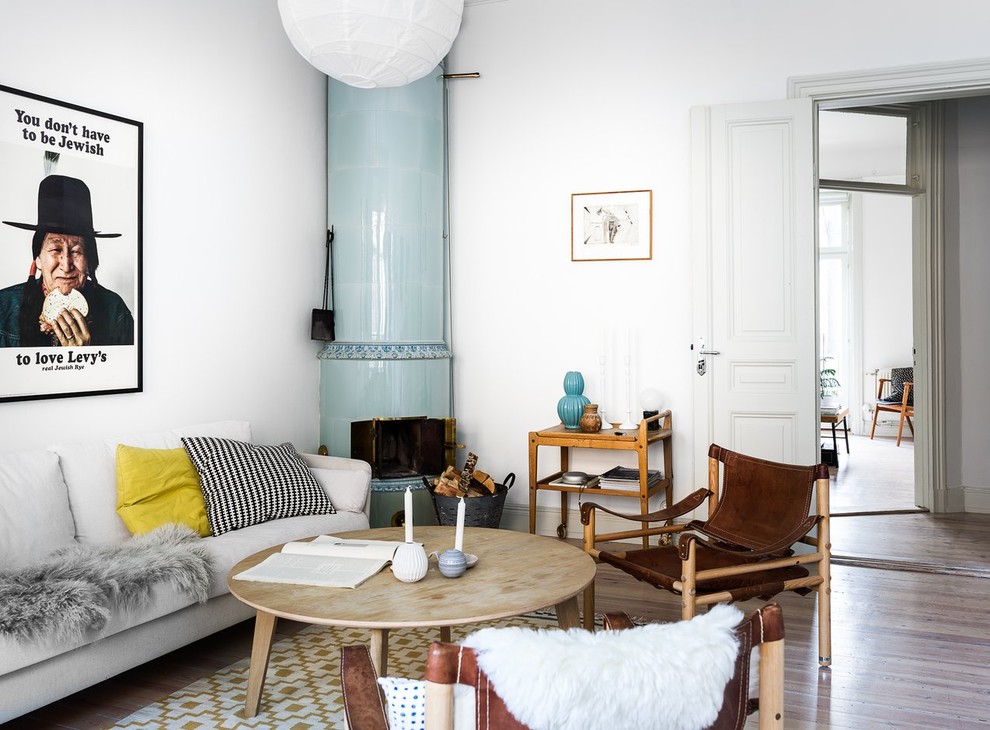 Foto på ett mellanstort minimalistiskt separat vardagsrum, med vita väggar, mellanmörkt trägolv, beiget golv och en öppen vedspis